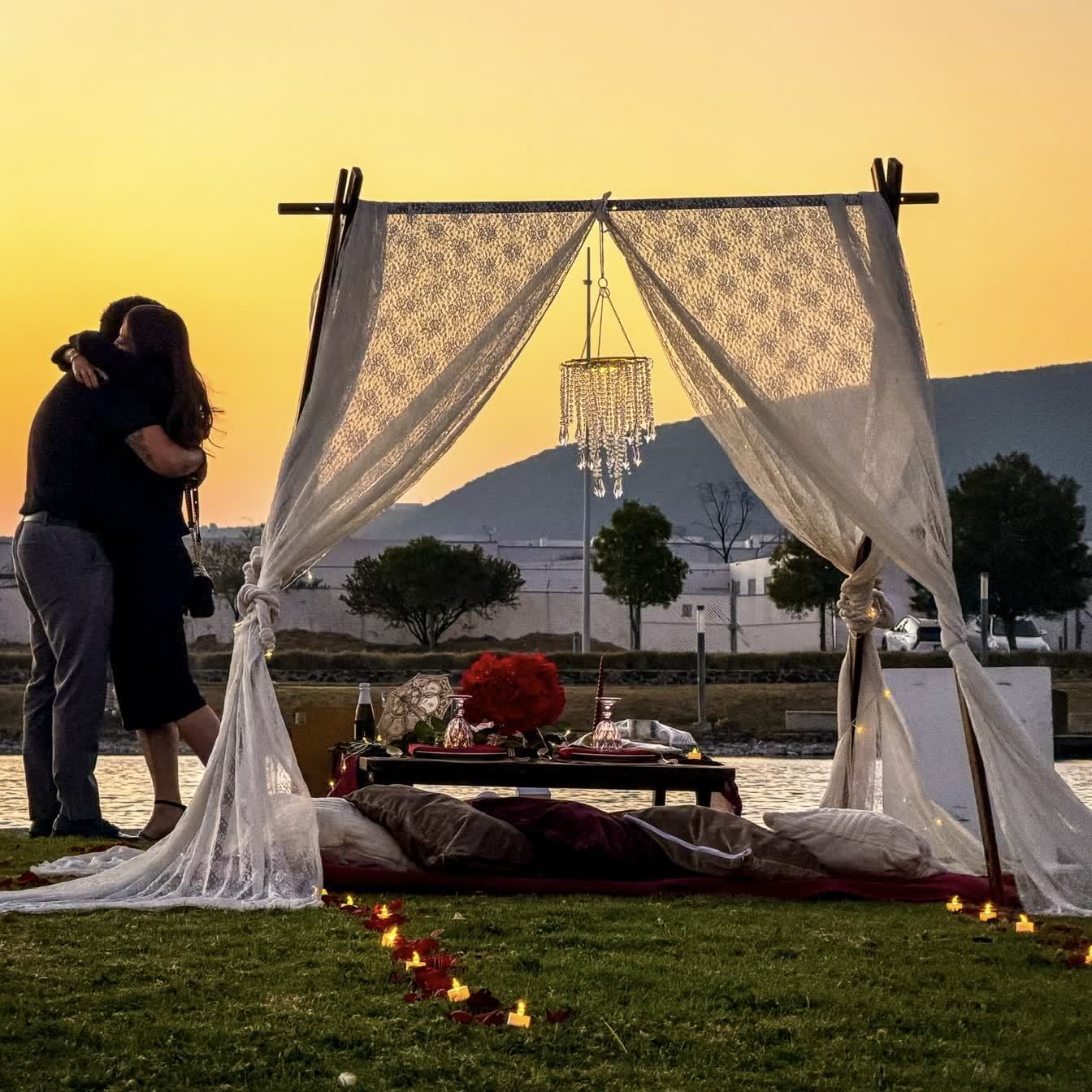 Picnic teepee junto al lago con cojines al atardecer