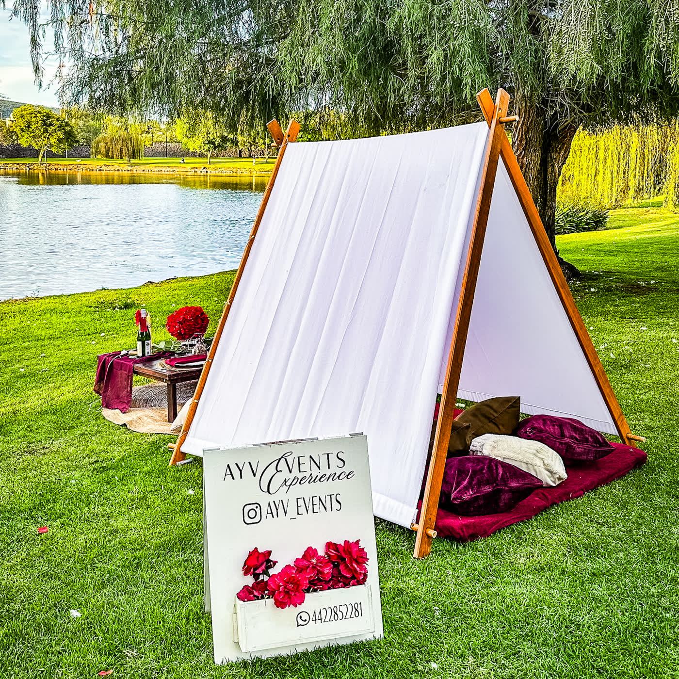 Pareja abrazada junto a teepee de encaje con candelabro al atardecer