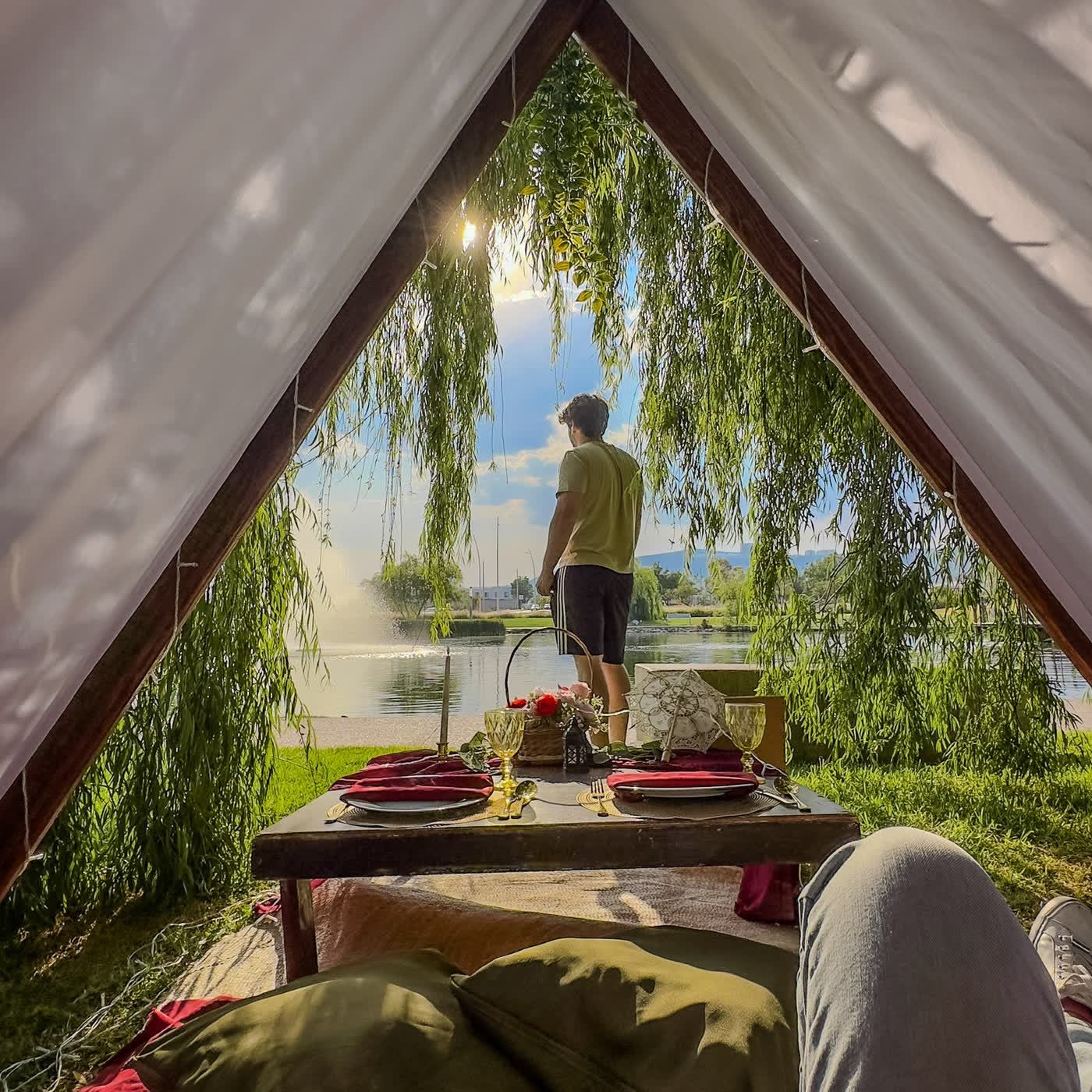 Teepee de encaje junto al lago con candelabro al atardecer