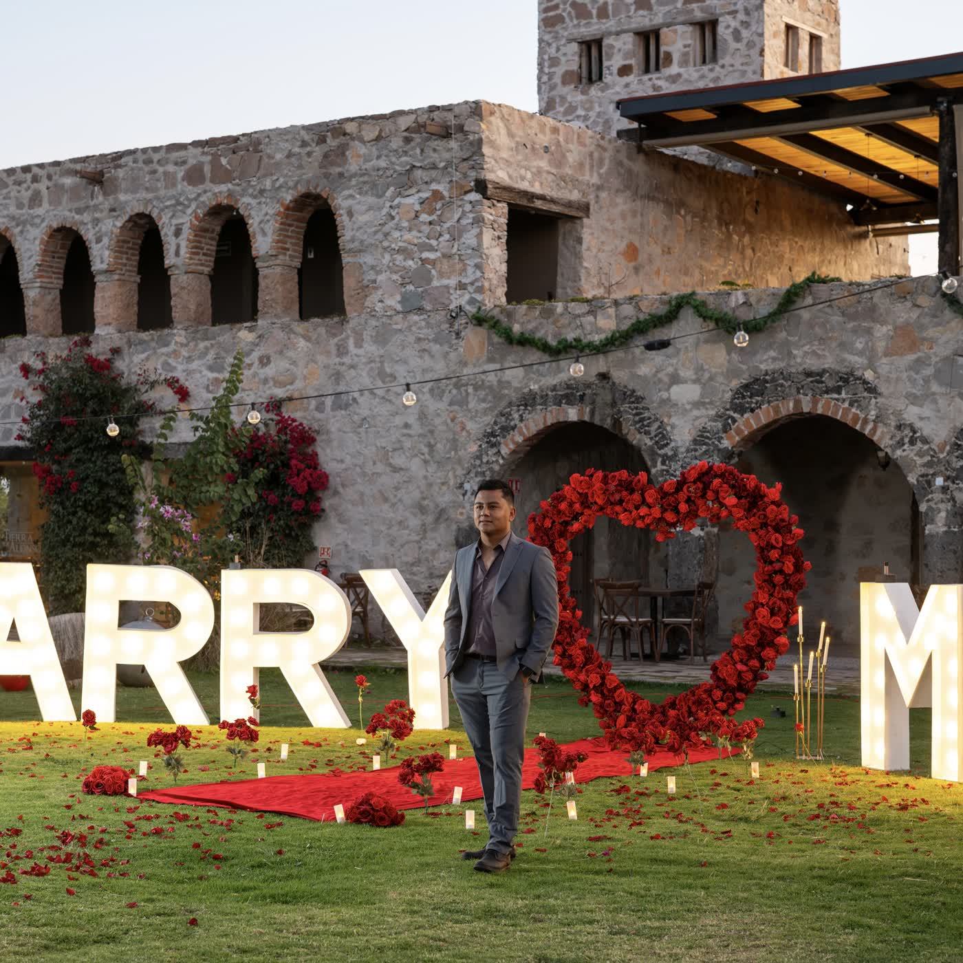 Letras gigantes MARRY ME con corazón de rosas rojas en hacienda de cantera